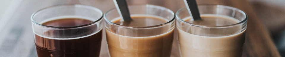 Stock photo of three glasses of coffee with varying amounts of creamer.